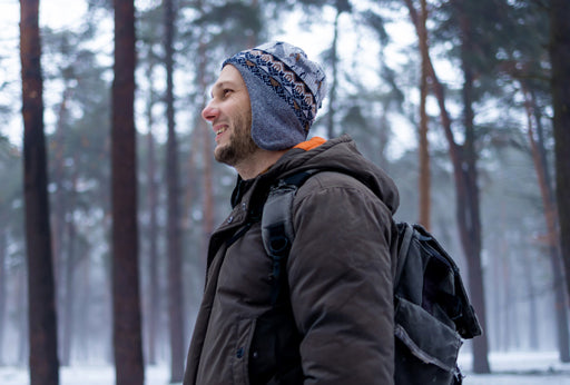 Mann mit Winterjacke und Rucksack genießt die Natur – idealer Einsatzmoment für das transparente Nasenpflaster von Airstripes.